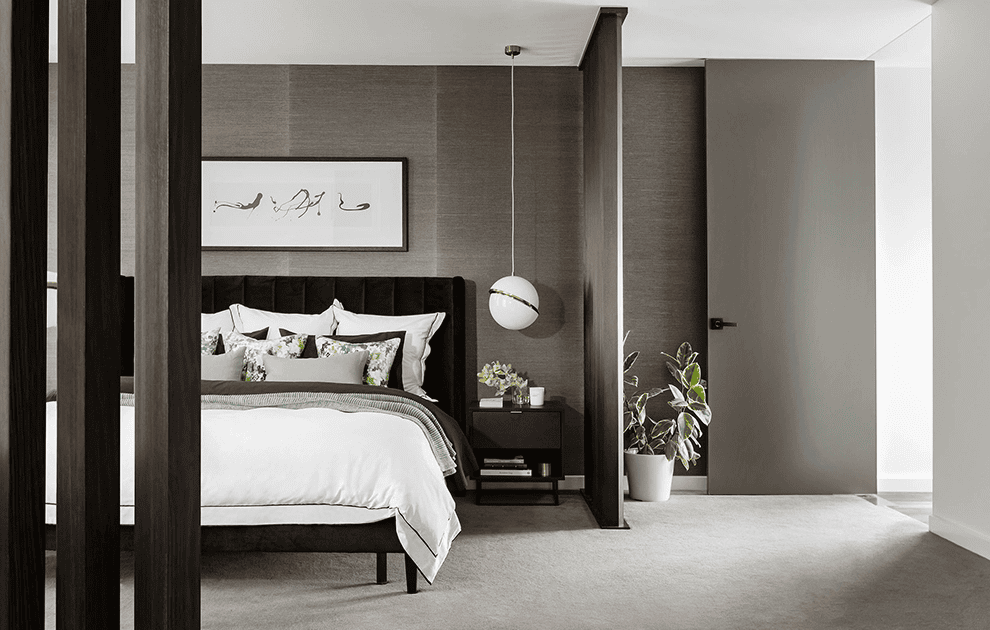 Bedroom with grey feature wall, bed, side table and indoor plant